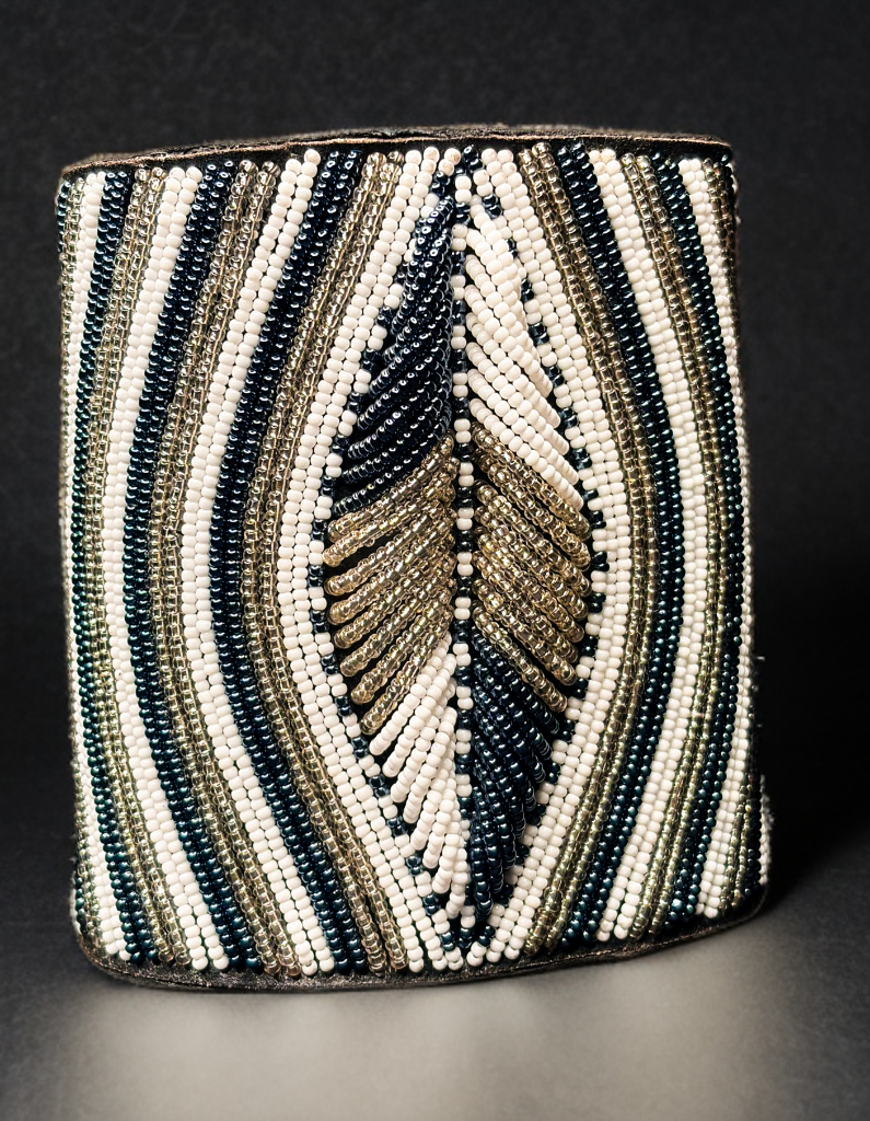 Beaded cylindrical container with feather design on a dark background