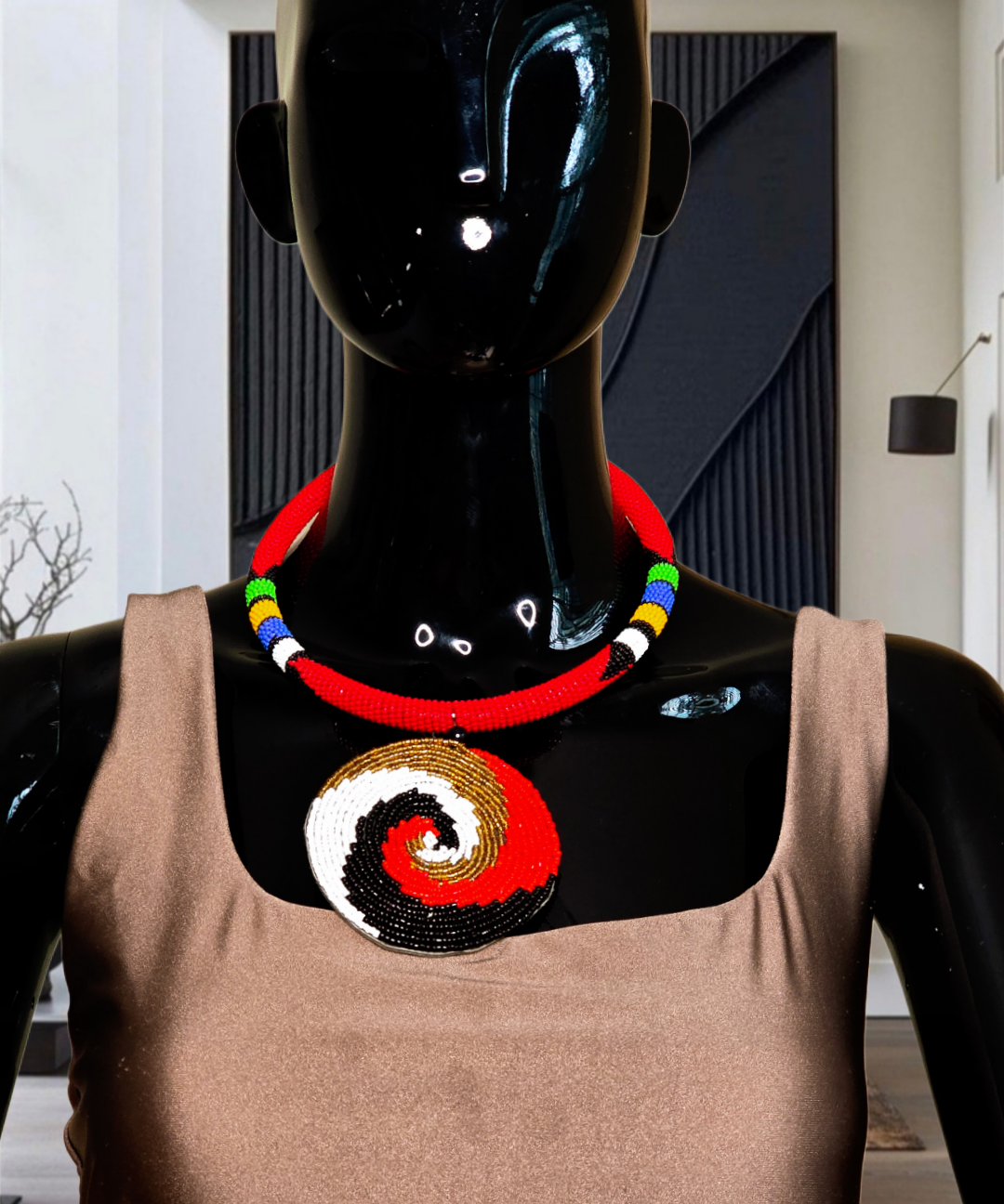 Mannequin wearing a colorful beaded necklace and a brown top with a spiral design.