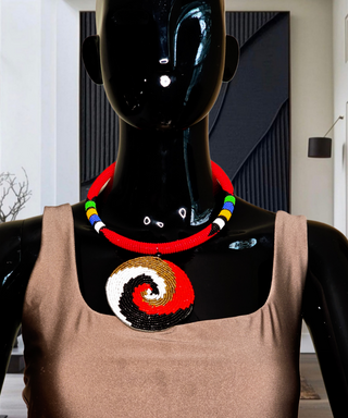Mannequin wearing a colorful beaded necklace and a brown top with a spiral design.