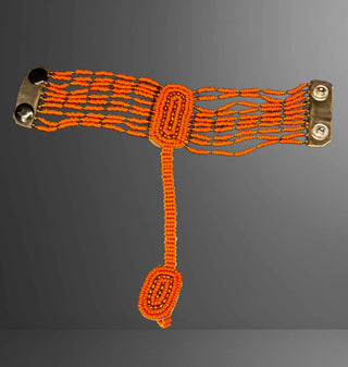 Orange beaded accessory with gold clasps on a gray background