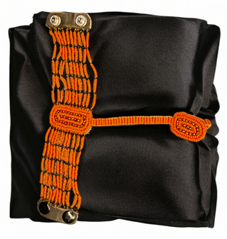 Black bag with orange strap featuring metal clasps on a white background