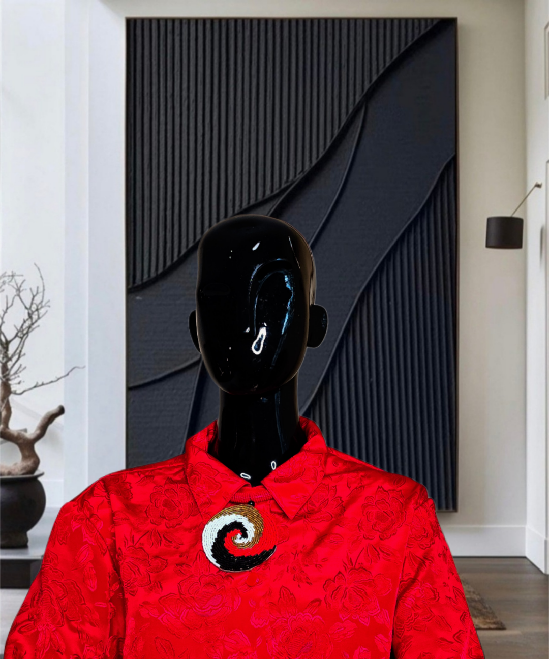 Mannequin wearing a red shirt with a black and white design in a room with a black textured wall.