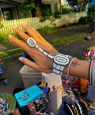 Hand with multiple rings and bracelets in a casual outdoor setting